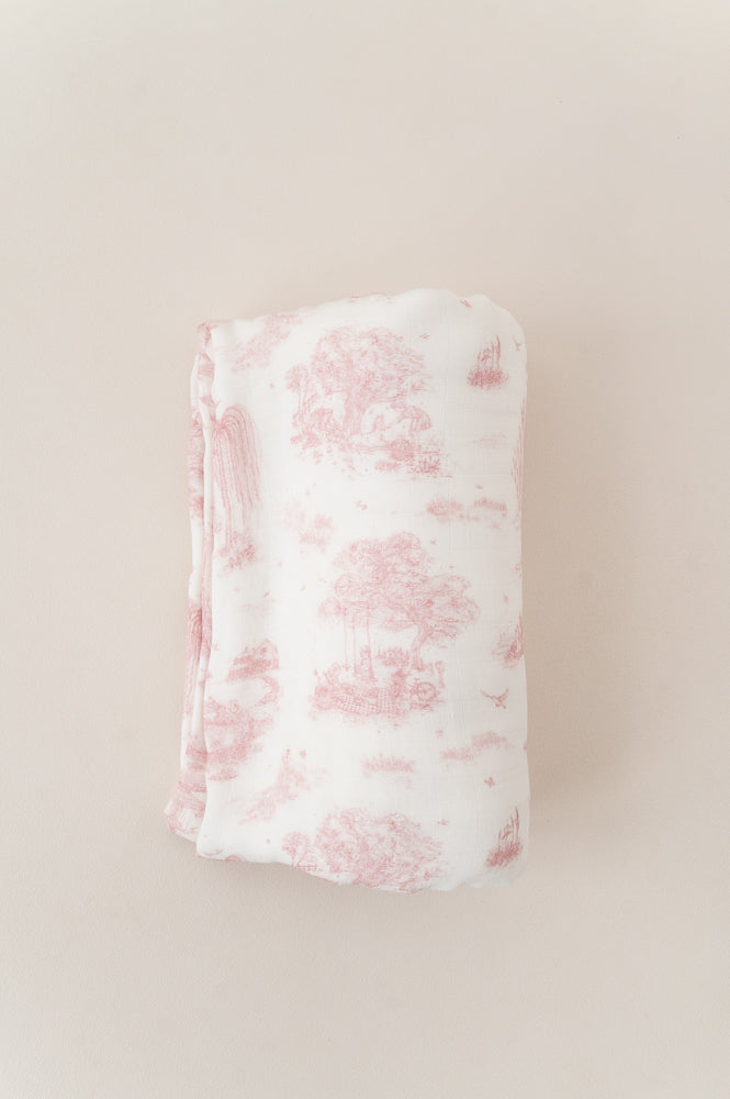 Folded Spring Toile Pink bamboo baby blanket on a neutral background, showing its pink pastoral print and stitched edge.